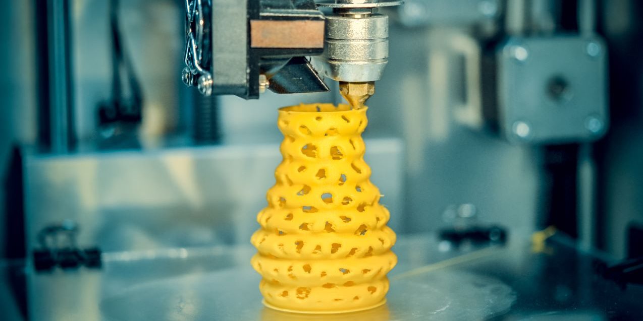 3d printer printing objects yellow form closeup. Modern technical 3D printing.